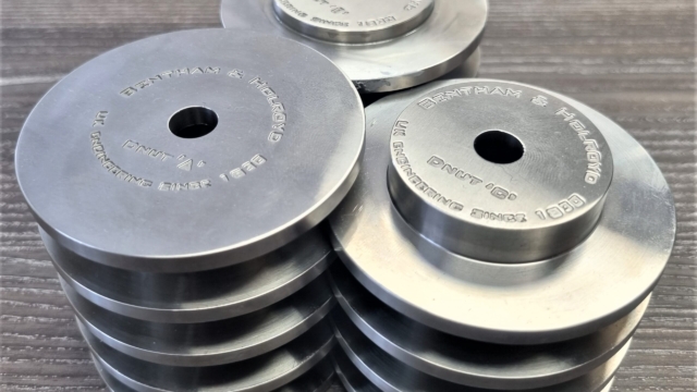 Stack of silver chuck donut adapters on a wooden table